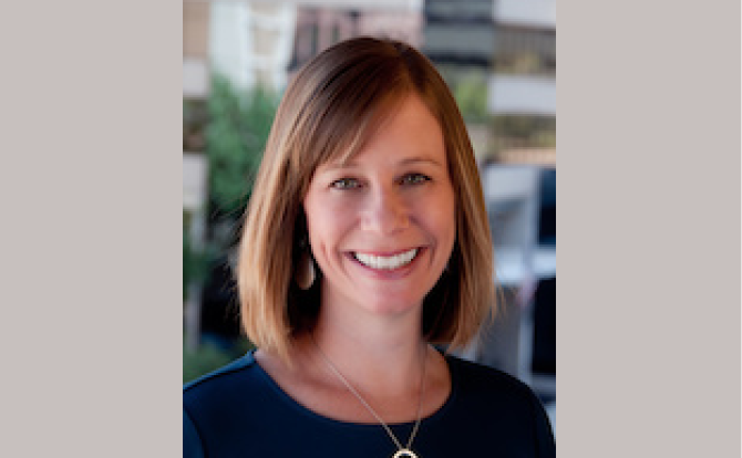 Women's headshot with buildings in background