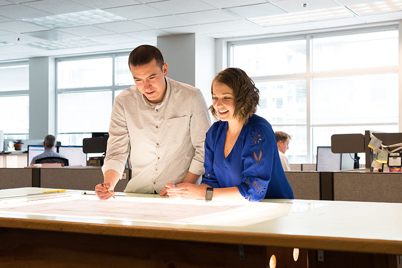 Two DEA staff conferring over a light table